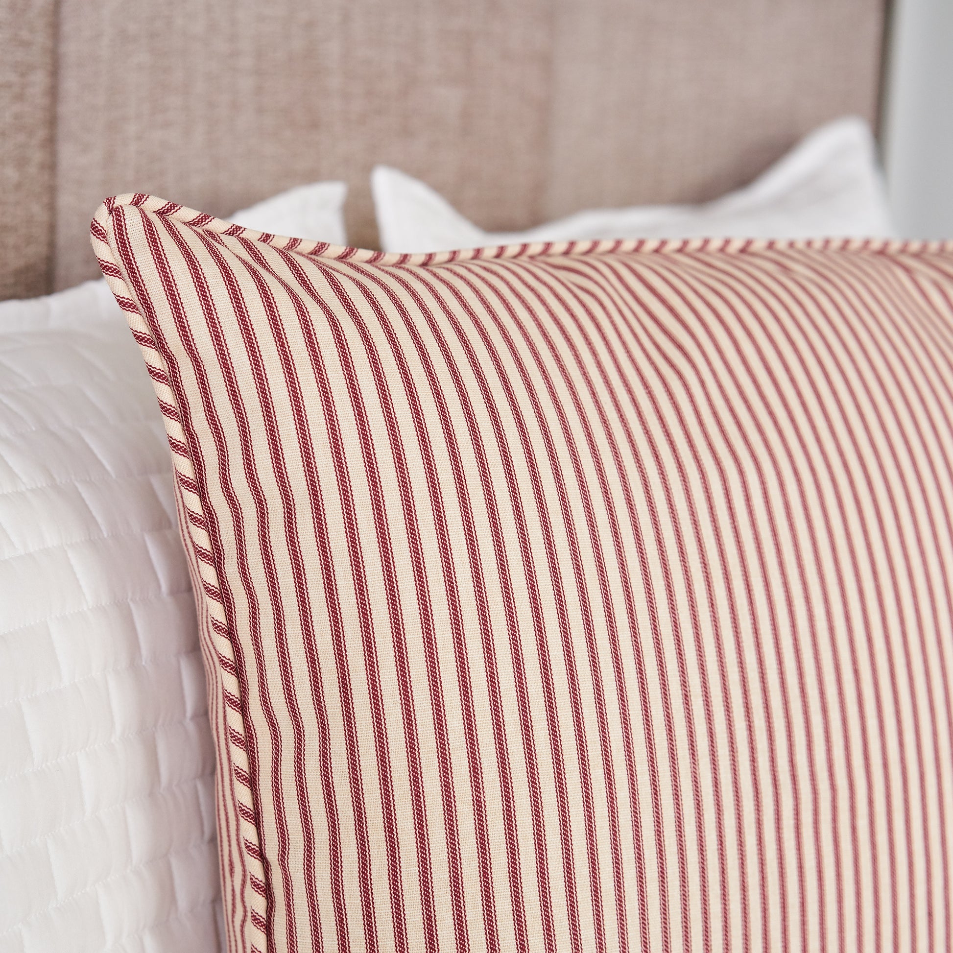 detail of red striped pillow sham on bed