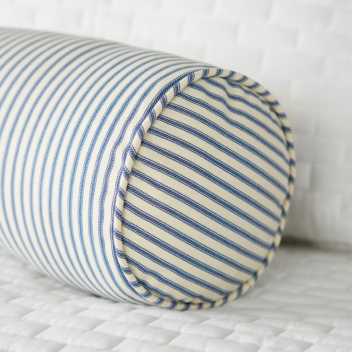 Blue Ticking Stripe Bolster Pillow on White Bed